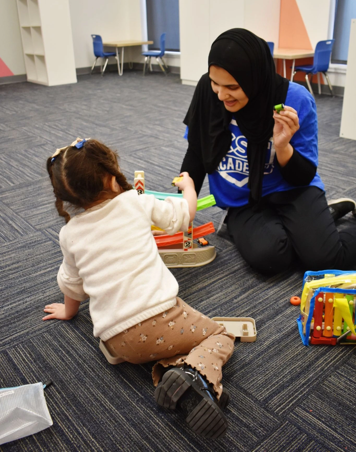 A CST Academy team member playing with a young child during a session